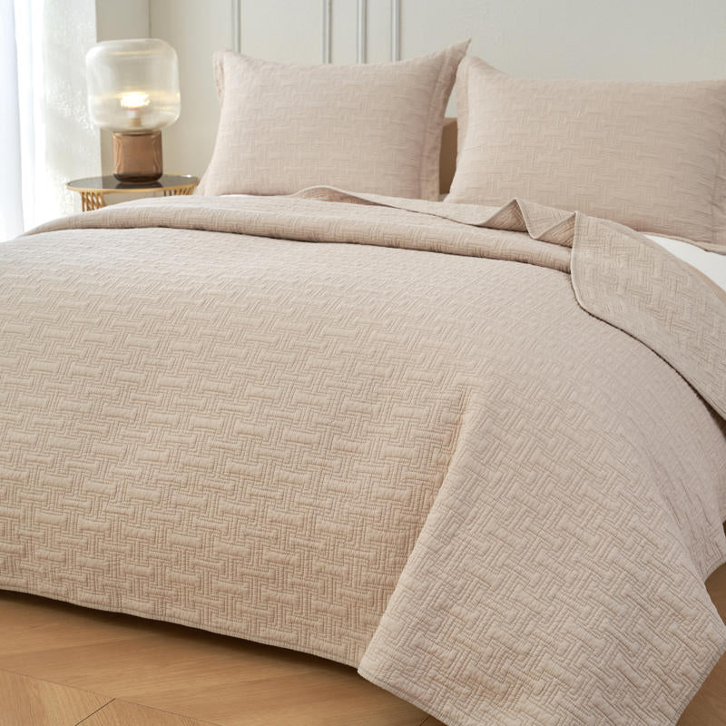 Soft neutral cotton throw with detailed stitching and bound edges.