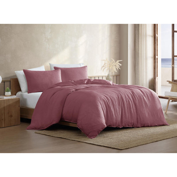 Warm pink quilt cover set styled in coastal-inspired neutral bedroom.