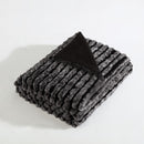 Ardor Boudoir Cole Ash Faux Fur Throw draped over a sofa in a modern living room