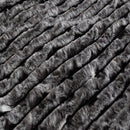 Ardor Boudoir Cole Ash Faux Fur Throw draped over a sofa in a modern living room