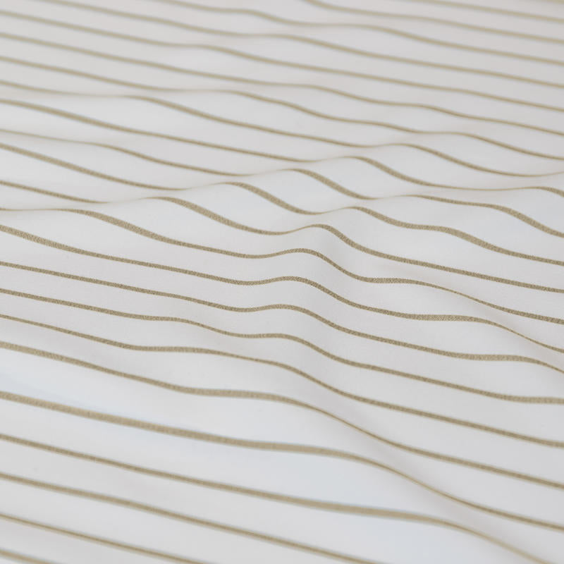 Neutral stripe quilt cover set creating a calm, minimal bedroom look.