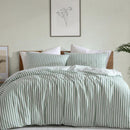 Coastal-inspired sage and white stripe quilt cover set in a relaxed modern bedroom.