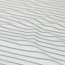 Coastal-inspired sage and white stripe quilt cover set in a relaxed modern bedroom.