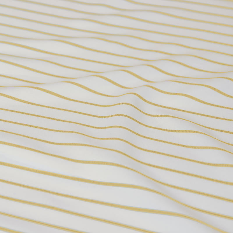 Bright and cheerful yellow stripe quilt cover set in a modern bedroom.