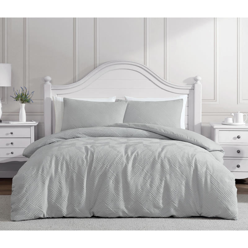 Soft silver quilt cover with matching pillowcases in modern bedroom.