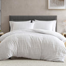 Close-up of white quilt cover fabric showing detailed stitched pattern.