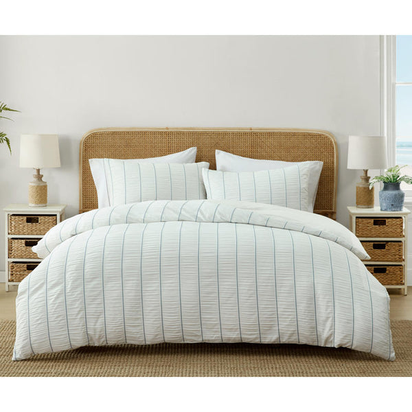 Light and airy blue striped quilt cover set on white bed.
