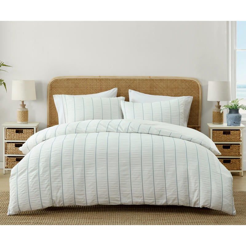 Light and airy blue striped quilt cover set on white bed.