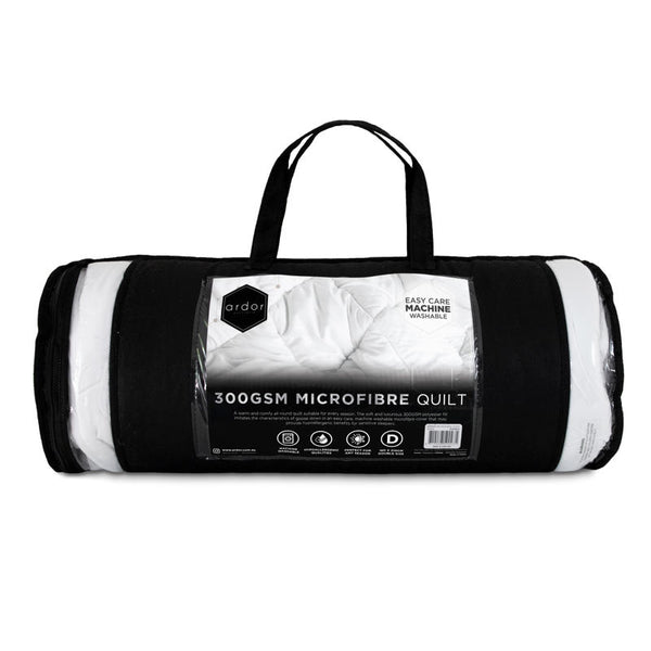 Rolled white microfibre quilt on plain background.