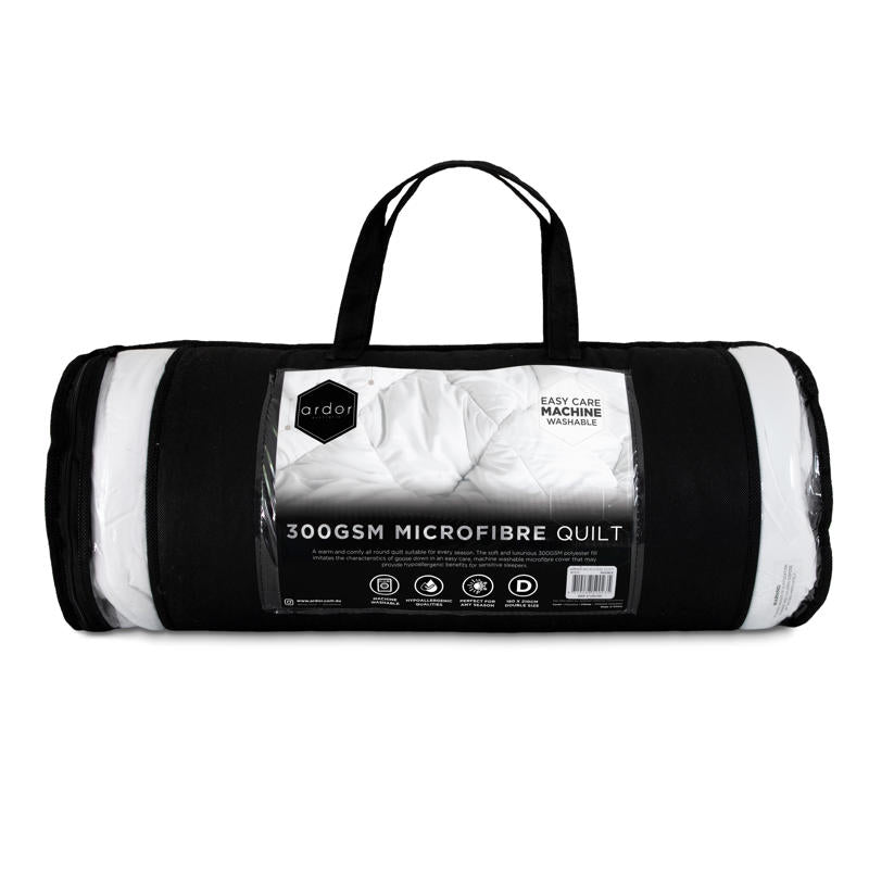 Rolled white microfibre quilt on plain background.