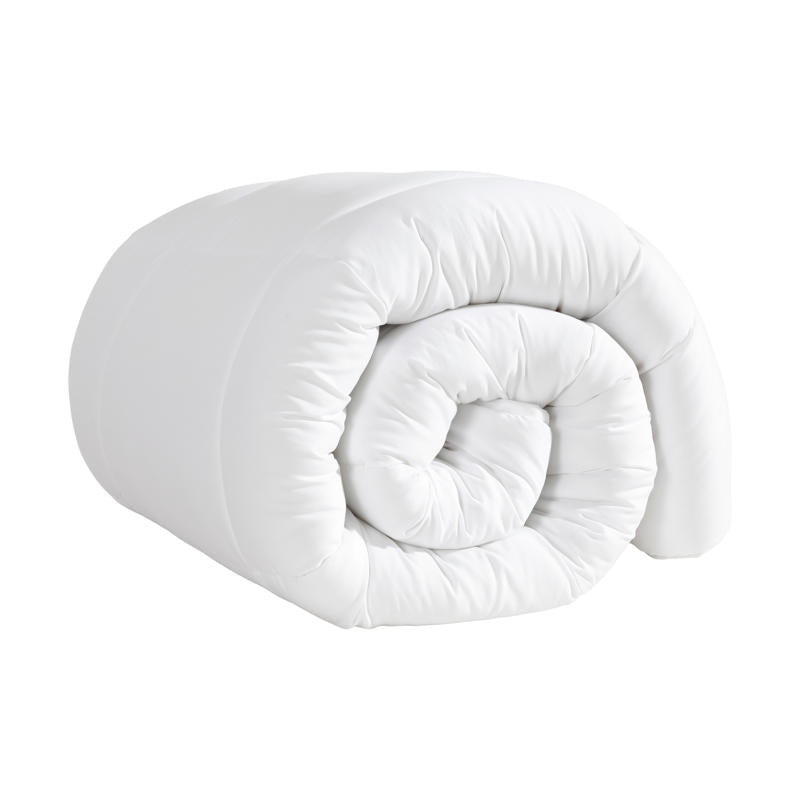 Rolled white microfibre quilt on plain background.