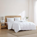 Rolled white microfibre quilt on plain background.