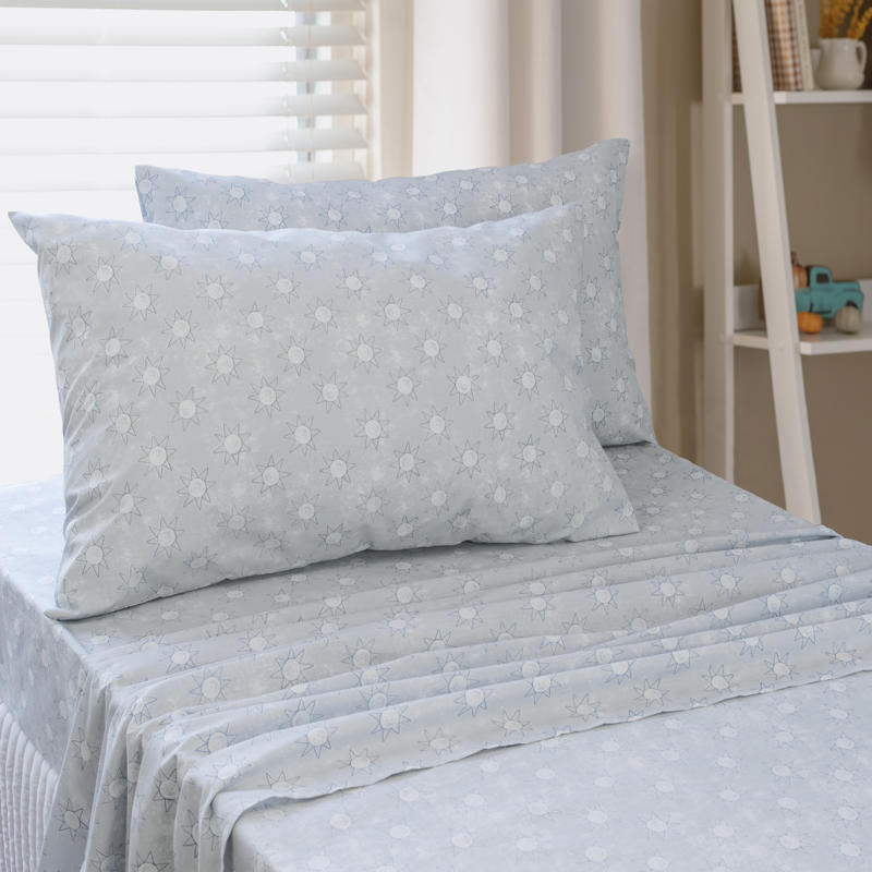 Close-up of playful blue sun print pattern on kids sheet set.