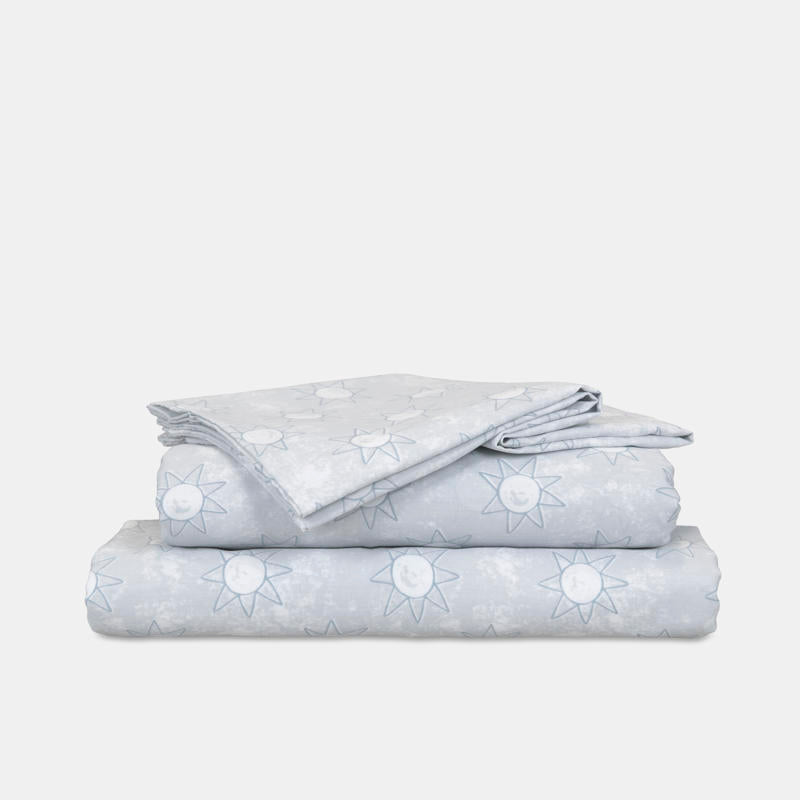 Close-up of playful blue sun print pattern on kids sheet set.