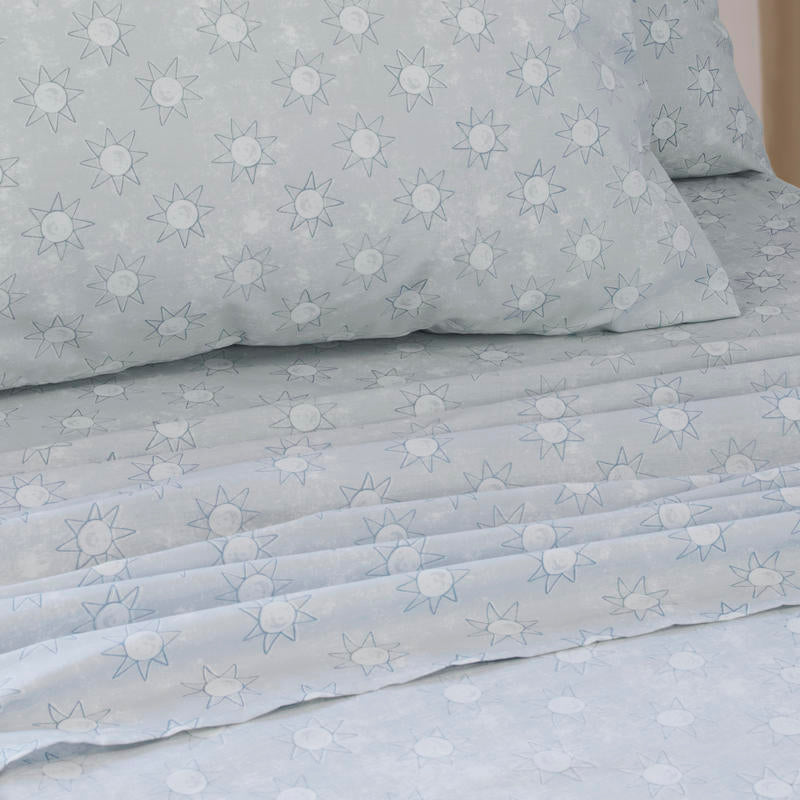 Close-up of playful blue sun print pattern on kids sheet set.