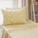 Close-up of white cloud pattern on yellow kids sheet set.