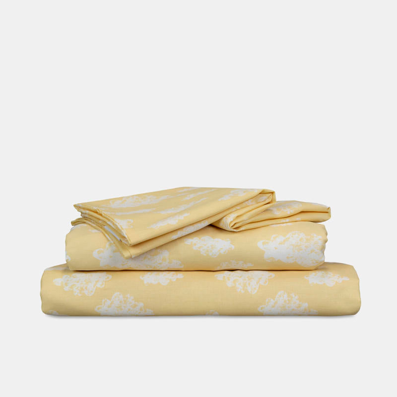 Close-up of white cloud pattern on yellow kids sheet set.