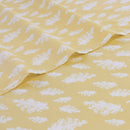 Close-up of white cloud pattern on yellow kids sheet set.