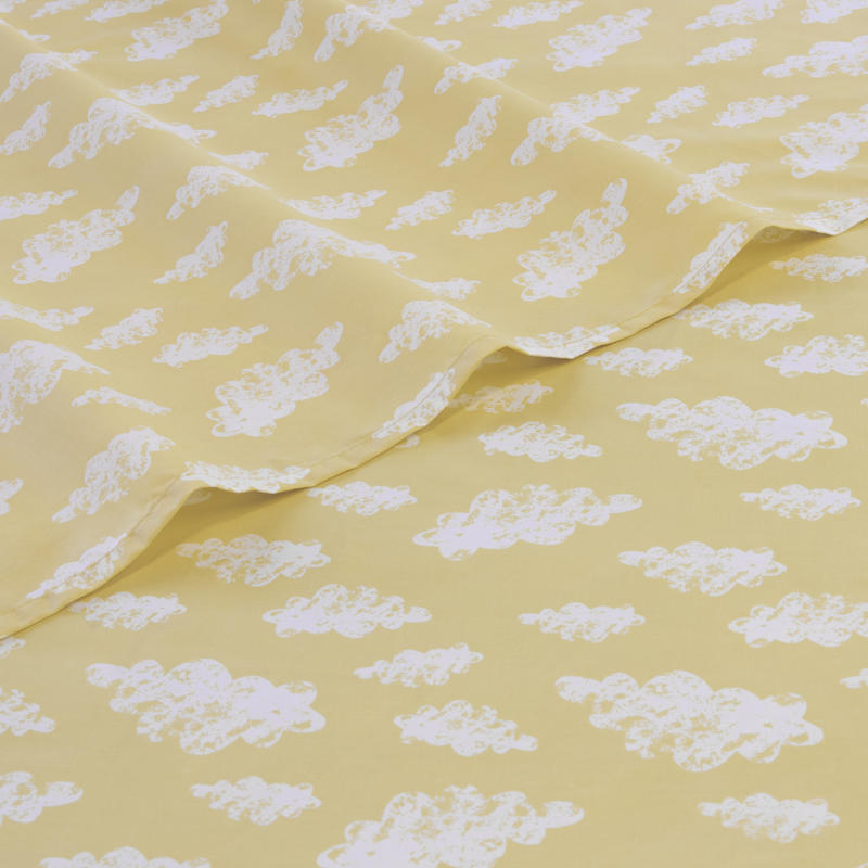 Close-up of white cloud pattern on yellow kids sheet set.