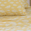 Close-up of white cloud pattern on yellow kids sheet set.