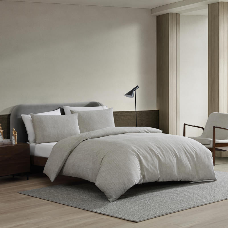 Kenneth Cole Herringbone Moss Quilt Cover Set styled on bed with neutral walls and modern décor.