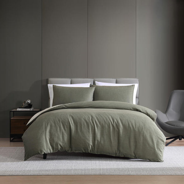 Modern interior with Kenneth Cole Nila Moss Green Quilt Cover Set on grey bedhead and neutral rug.