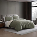 Modern interior with Kenneth Cole Nila Moss Green Quilt Cover Set on grey bedhead and neutral rug.