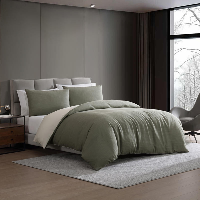 Modern interior with Kenneth Cole Nila Moss Green Quilt Cover Set on grey bedhead and neutral rug.
