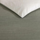 Modern interior with Kenneth Cole Nila Moss Green Quilt Cover Set on grey bedhead and neutral rug.