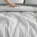 Reversible comforter showing light and dark grey tones.