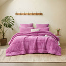 A vibrant crocus pink Snuggle Fleece Comforter set with layered pillows, adding warmth and colour to a modern bedroom.