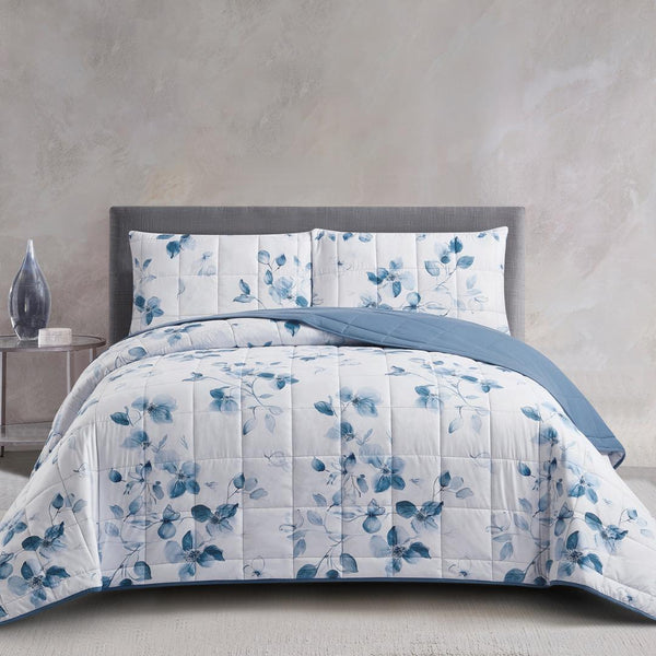 Lightweight quilted coverlet with matching pillowcases in soft blue floral design.