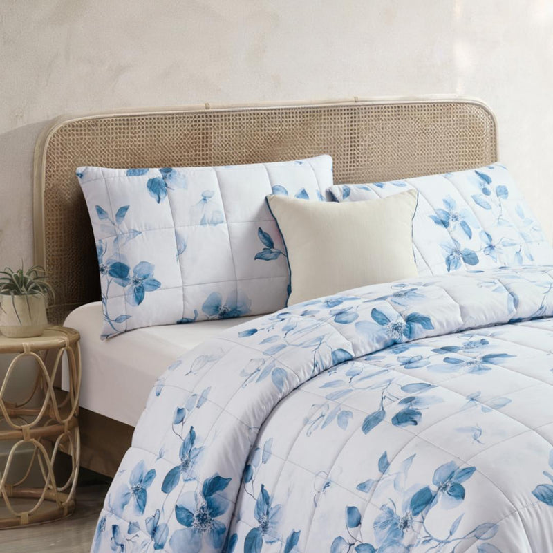 Lightweight quilted coverlet with matching pillowcases in soft blue floral design.