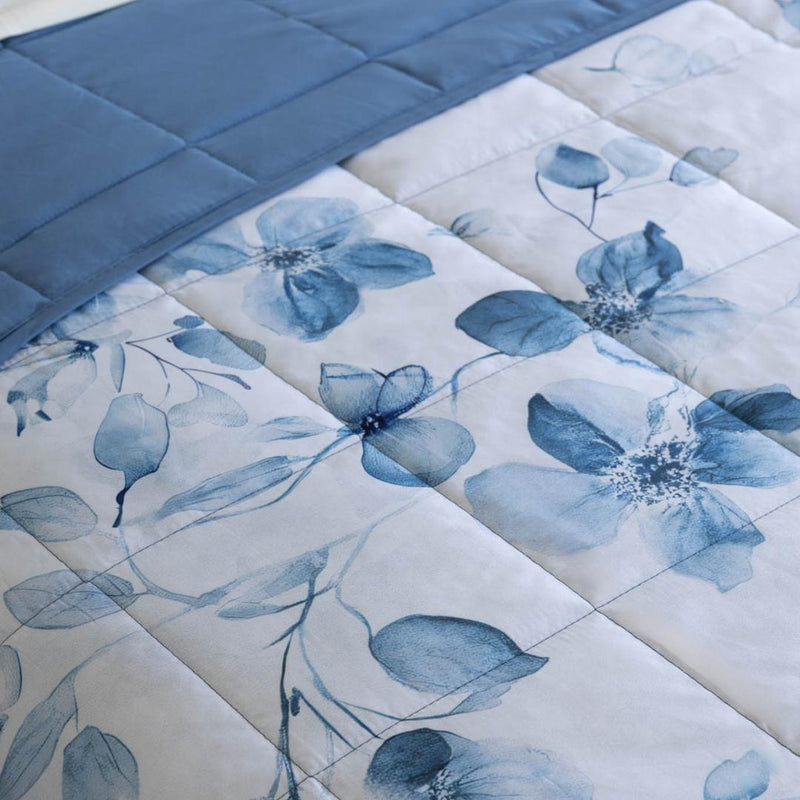 Lightweight quilted coverlet with matching pillowcases in soft blue floral design.