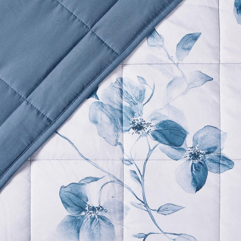 Lightweight quilted coverlet with matching pillowcases in soft blue floral design.
