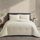 Lightweight coconut cooling comforter layered on rattan bed frame.