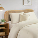 Lightweight coconut cooling comforter layered on rattan bed frame.
