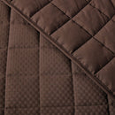 Close-up of a brown quilted fabric with a diamond pattern