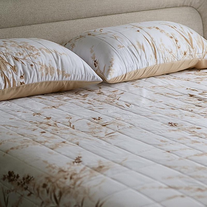 Close-up of golden floral quilted design and stitching.