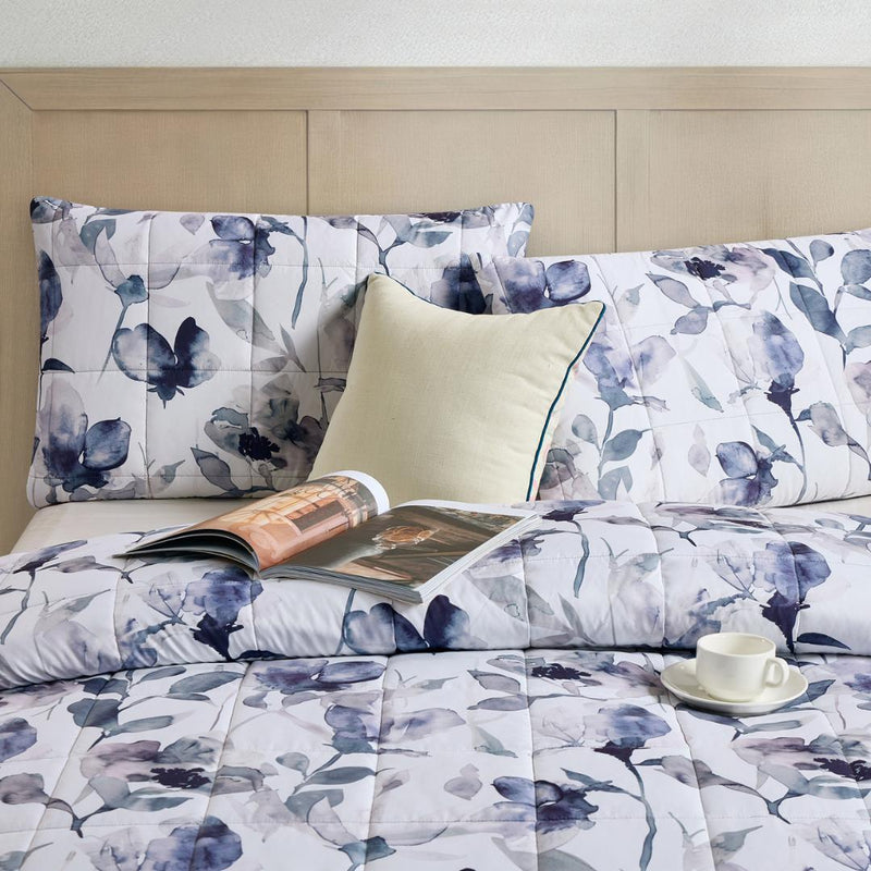 Close-up of watercolour floral quilted fabric in grey and indigo.