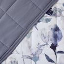 Close-up of watercolour floral quilted fabric in grey and indigo.