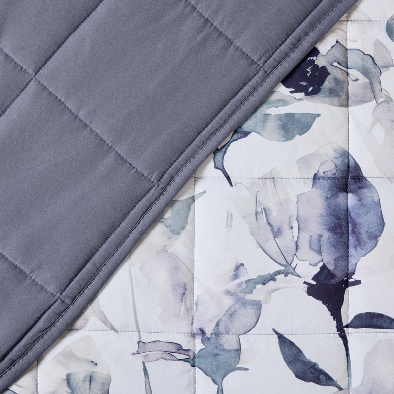 Close-up of watercolour floral quilted fabric in grey and indigo.