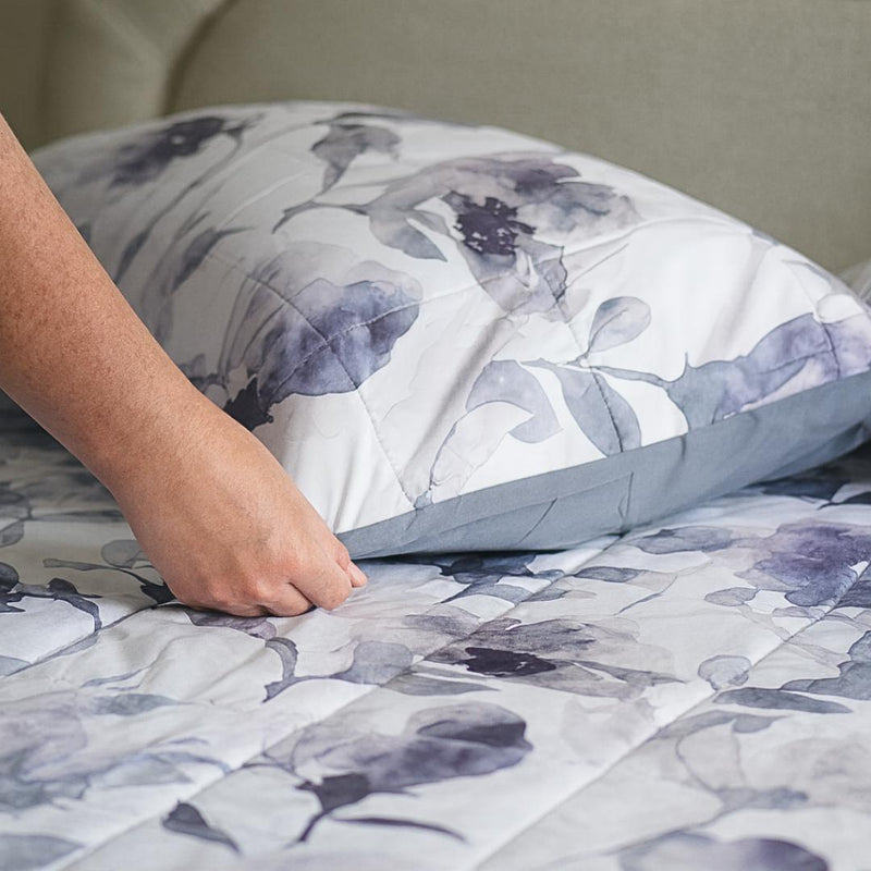 Close-up of watercolour floral quilted fabric in grey and indigo.