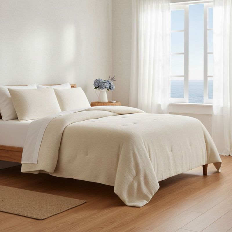 Neatly made bed with white bedding in a bright bedroom