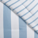 A fresh coastal bedroom features the Morgan and Reid Sea Breeze Stripe Comforter Set on a neatly styled bed with striped pillows, rattan bedhead, textured rug, natural pendant lighting, and a leafy plant beside the bed.