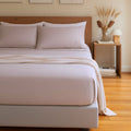 Neatly made bed with light bedding in a bedroom setting.