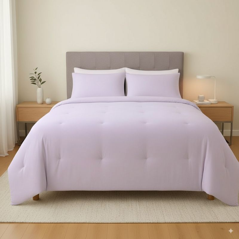 Bed with lavender bedding and pillows in a bedroom setting