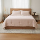 Bedroom with a wooden bed frame, pink bedding, and nightstands.