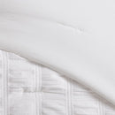 A clean modern bedroom highlights the Morgan and Reid Whispers of White Comforter Set with matching pillowcases, rattan bedhead, neutral-toned walls, woven pendant lamp, indoor greenery, and a simple wooden side table.