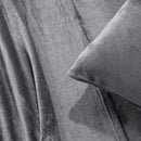 A modern bedroom with a beige upholstered bed and cream bedding exudes winter comfort, enhanced by the Morgan and Reid Winter Microplush Sheet Sets ultra-soft fabric, neutral decor, dried flowers, and light wood floors.